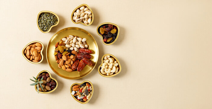 Mixed nuts and dried fruits on a gold plates. Symbols of the Jewish holiday of Tu Bishvat. Healthy snack - mix of organic nuts and dry fruits.