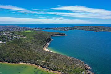 High angle aerial drone view of Grotto Point and Washaway Beach in the suburb of Clontarf, Sydney, New South Wales, Australia. Manly and North Head in the background.