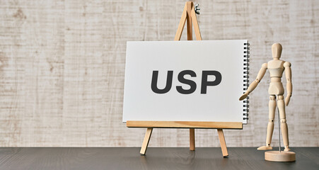There is notebook with the word USP. It is an abbreviation for Unique Selling Proposition as eye-catching image.