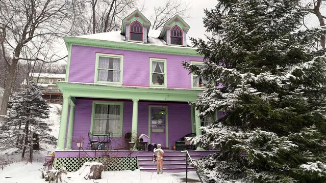 A slowly creeping forward dolly shot view of a unique purple wooden home in the winter. Pittsburgh suburbs.  	