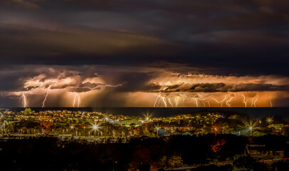 Nature's wrath descends upon the city as the lightning and thunder clash in a dramatic nighttime...