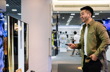 Customer Using Smartphone in Electronics Department