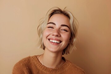 Smiling pretty gen z blonde young woman, cute happy 20s european student girl with short blond hair and white dental smile looking at camera standing isolated on beige background, portrait - obrazy, fototapety, plakaty