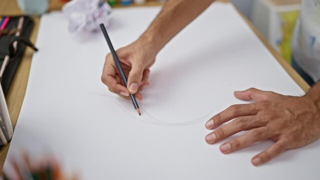 Hispanic man's hands drawing with fervor in art studio, sketching life on paper with pencil