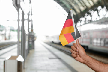 Man with German flag at railway station, closeup