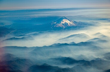 An aerial shot of Mt Hood with fog laying in the valleys surrounding the mountain, near Portland, Oregon. - Powered by Adobe