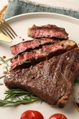 Delicious grilled beef steak and rosemary on plate, closeup