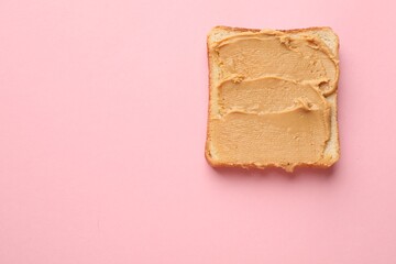 Tasty peanut butter sandwich on pink background, top view. Space for text
