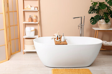 Different personal care products and accessories on bath tub in bathroom