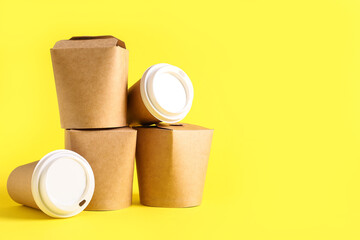 Takeaway paper cups and boxes on yellow background