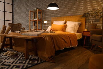 Interior of bedroom with glowing lamps and wooden bench at night