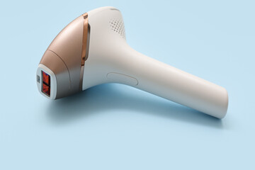 Modern photoepilator on blue background