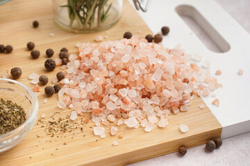 Board with Himalayan pink salt and peppercorn on white background