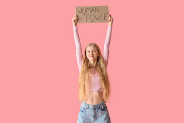 Young girl holding paper with text WOMAN POWER on pink background