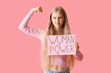 Young girl holding paper with text WOMAN POWER on pink background