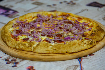 Traditional Brazilian pepperoni pizza with purple onion in selective focus