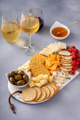 Small cheese and cracker board with fresh berries and olives