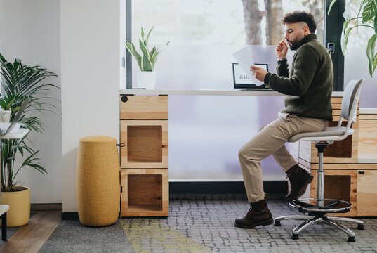 Businessman working in a creative office, strategizing for business success through market analysis and profit growth.
