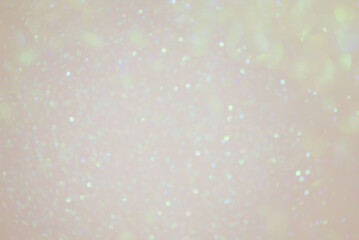 Beige background with green defocus lights. Abstract glitter background. Bokeh