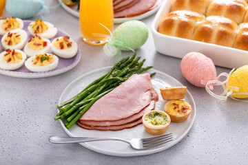 Easter brunch table with a potion of ham with asparagus on the plate