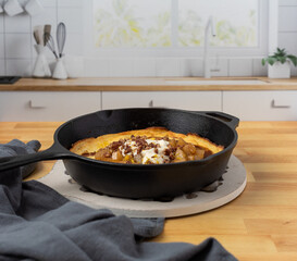 Lemon-Ricotta Dutch Baby with Pears in Cast Iron Skillet on Butcher Block Countertop
