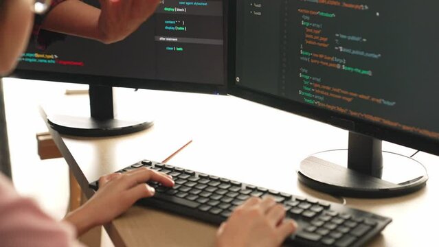 Back end or software developer manager supervising his team on new application program development on debugging and solving complex code algorithms on monitor. Burgeoning