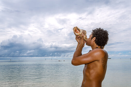 Local tahitian man blowing a conch shell, Moorea, French Polynesia