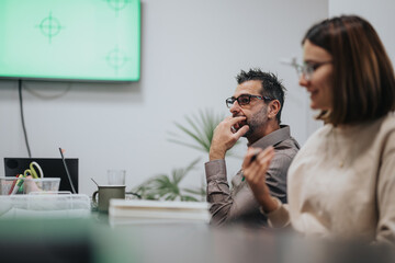 Diverse business professionals collaborate in a corporate office, discussing ideas for business growth and market expansion. Late evening meeting shows dedication to teamwork and project planning.