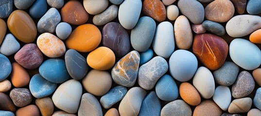 Close up of smooth, vibrant beach pebbles displaying textures and hues in radiant sunlight