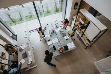 An aerial view of a spacious, well-lit office with diverse employees engaged in their tasks at...