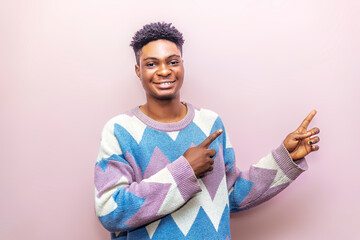 Young Man Pointing Sideways With Finger, Isolated on Pink Background
