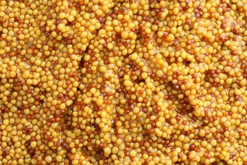 Whole grain mustard as background, top view