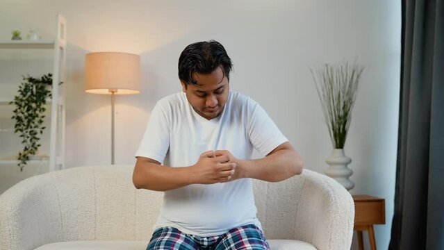 Indian man scratching his hand. Concept of itchy skin diseases such as scabies, fungal infection, eczema, psoriasis, allergy