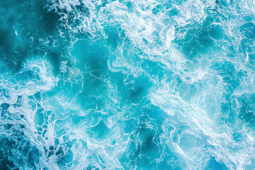 Obraz premium From above aerial view of turquoise ocean water with splashes and foam for abstract natural background and texture.
