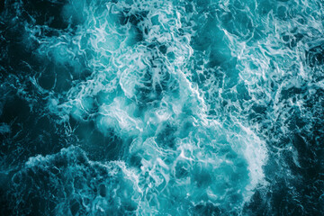 From above aerial view of turquoise ocean water with splashes and foam for abstract natural background and texture. - obrazy, fototapety, plakaty