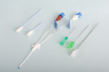 Central catheter kit elements, dilators, channeling needles. Instruments for surgery, surgery table, Isolated on light blue background, closed angle.