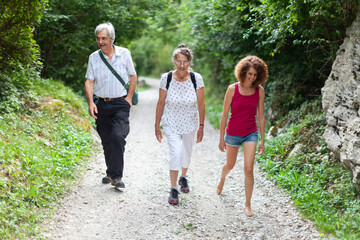 Fototapeta premium Senior Couple and their Mature Adult Daughter Having a Walk on Fresh Air Outdoors in Nature