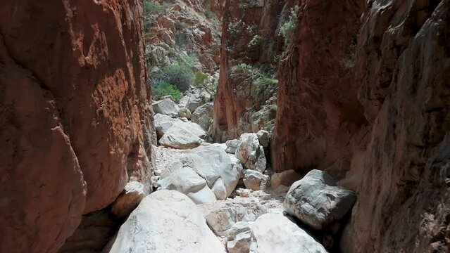 Aerial footage taken inside of the Standley Chasm shoing the huge size of the gorge with huge red rock faces on both sides.