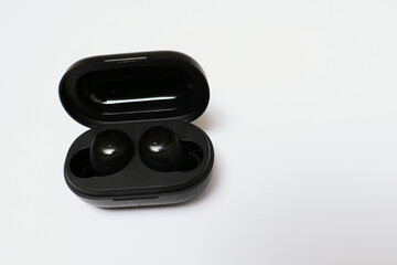 Wireless earbuds or earphones isolated on white background. Copy space and technology concept
