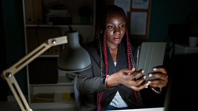 Confident african american woman boss making her success selfie on touchpad at office, nightfall