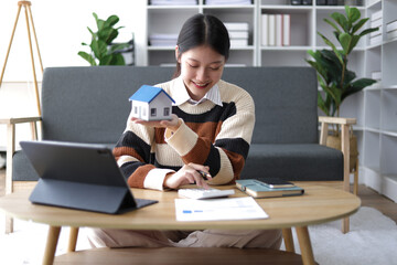 Young asian woman planning finances for down payment and home loan. Financial Planning and Accounting at Home