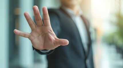 Closeup of the hand of a businessman showing stop, saying no or not accepting a deal in an office at work. Male corporate worker making hand gesture not agreeing to a statement or refusing - obrazy, fototapety, plakaty
