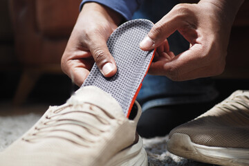 men hand putting Orthopedic insoles in shoes  - obrazy, fototapety, plakaty