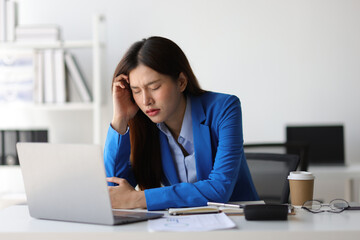 Asian businesswoman is stressed and has a headache from overwork.