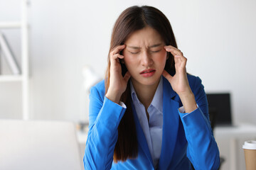 Asian businesswoman is stressed and has a headache from overwork.
