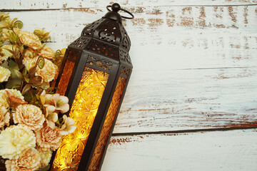 Black Moroccan Arabic lantern with flower on white table background