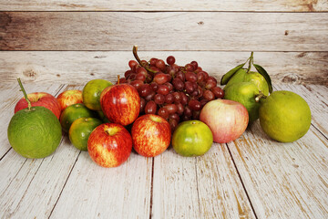 Various of fruits with Red grape, red apple and green orange on wooden background
