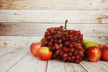 Various of fruits with Red grape, red apple and green orange on wooden background