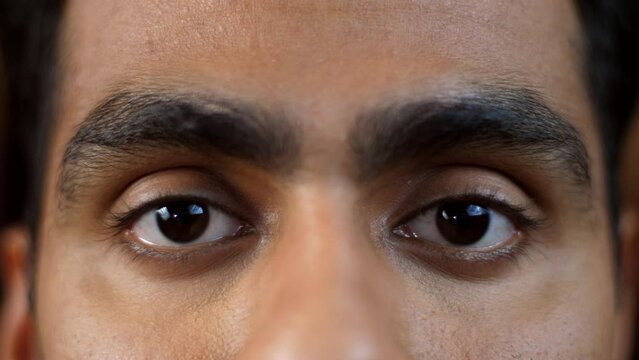 Close-up shot of an Indian male eyes - open eyes  black eyes  macro eyes  low eye vision  sleep deprivation  tired eyes  thick eyelashes. A young man undergoing an eye checkup for low vision- insom...