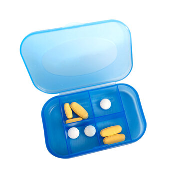 Pastillero azul con p&iacute;ldoras y tabletas comprimidas amarillas y blancas. Organizador de pastillas para tratamiento farmacol&oacute;gico con vista superior o &aacute;ngulo alto y fondo transparente. 
